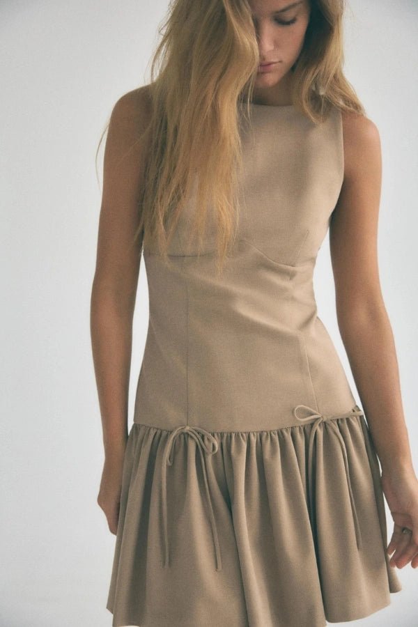 Mini dress with a ruffle design and bow, featuring a fitted silhouette, suitable for casual outings or summer events. 1